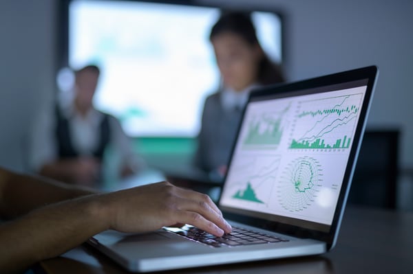 Businessman looking at charts on a laptop